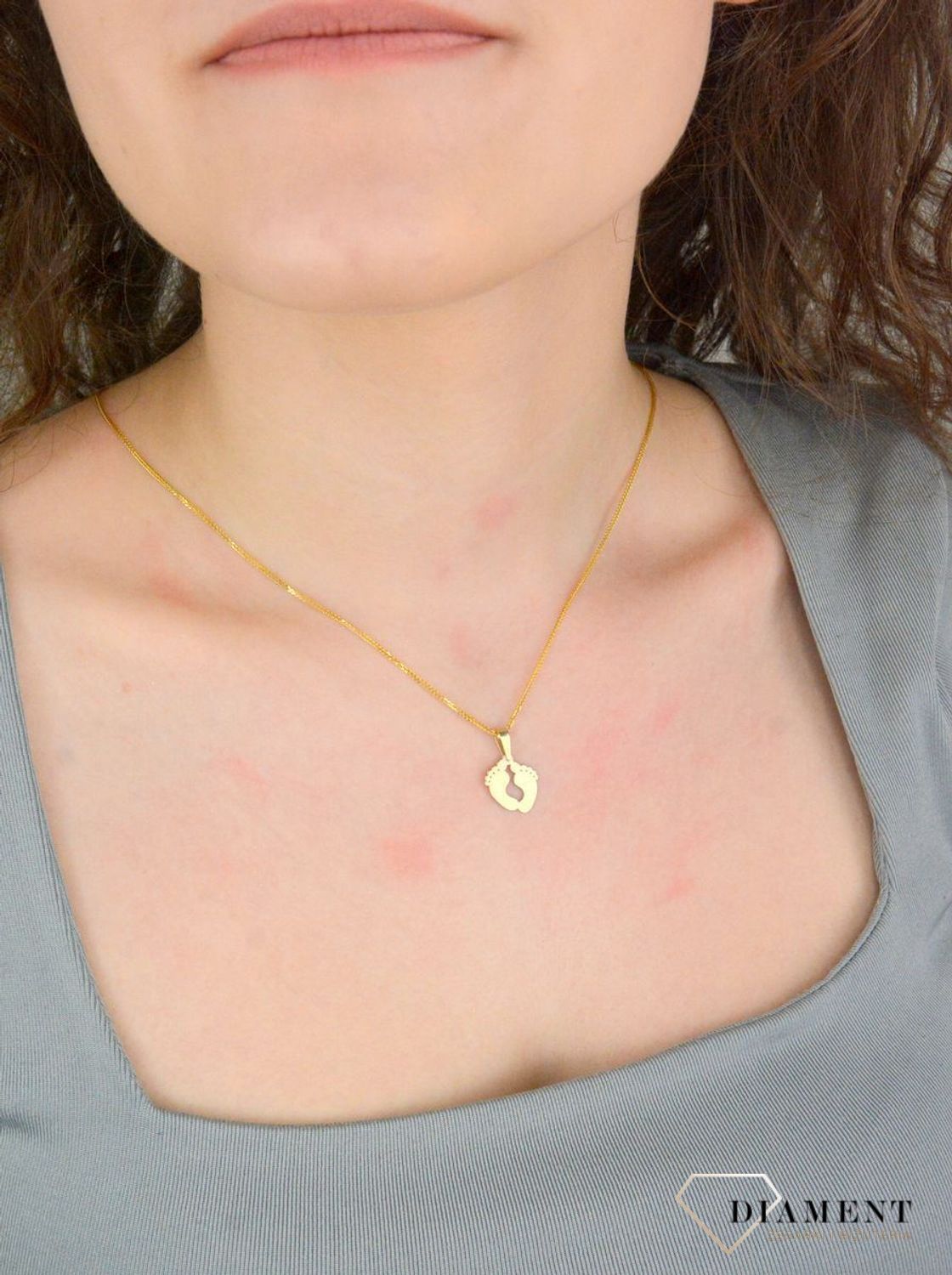 Zawieszka złota damska stopy stópki próba 375, ZA 5602 375  Piękny, złoty wisiorek o ciekawym wzorze wykonany z żółtego złota. Zawieszka w formie stópek. Wisiorek został wykonany z wysokiej jakości złota próby 375.1.jpg